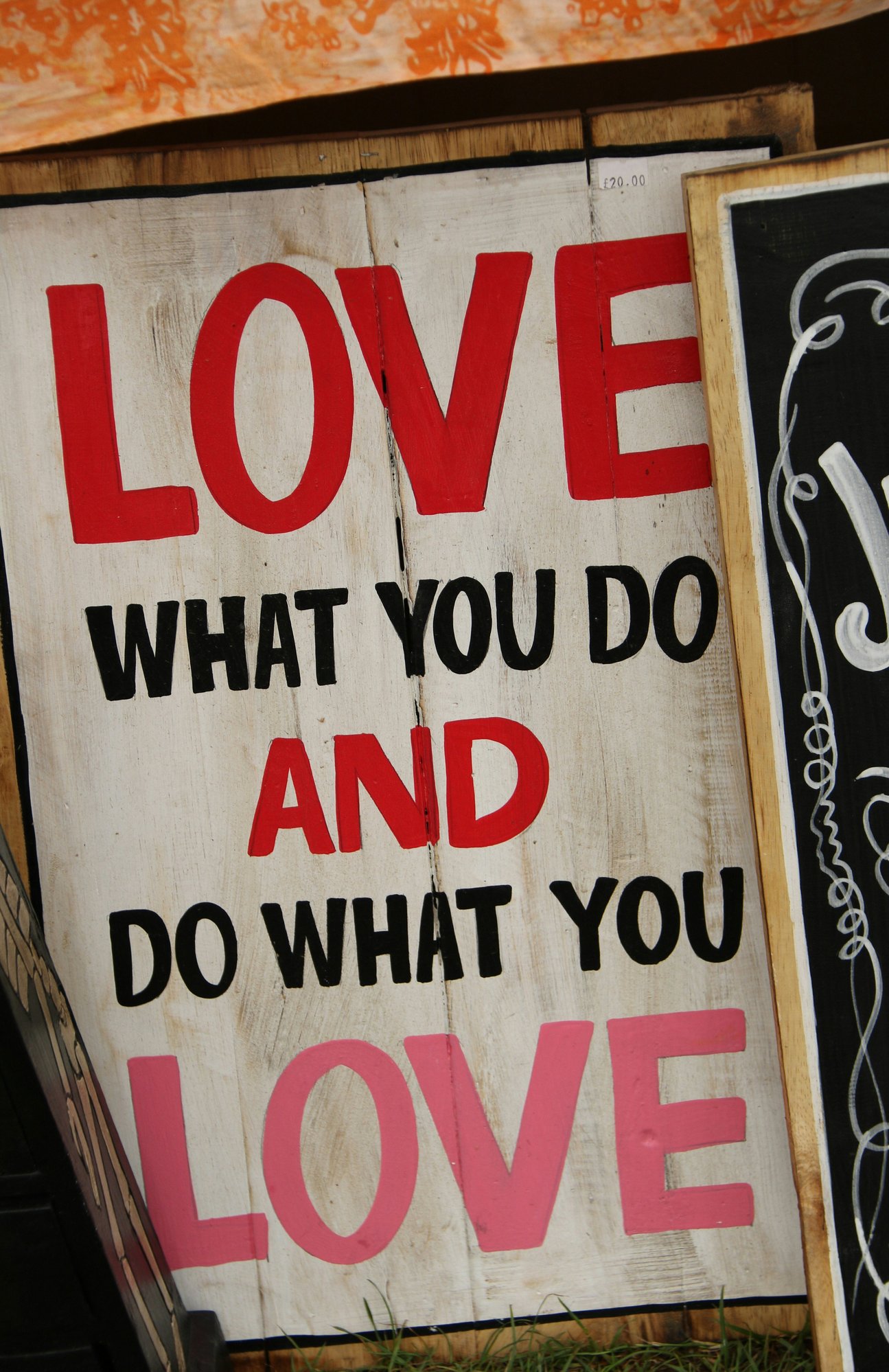 Four white-painted wood panels with 'Love what you do and do what you love' painted in uppercase, reflecting values-driven work.
